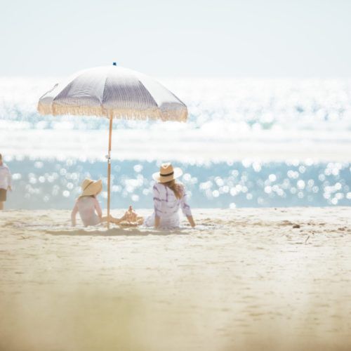 burleigh-currumbin-family-with-mother-and-daughter-under-umbrella-on-beach